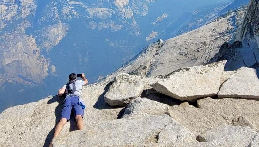 Brave man ooking over a cliff in Yosemite